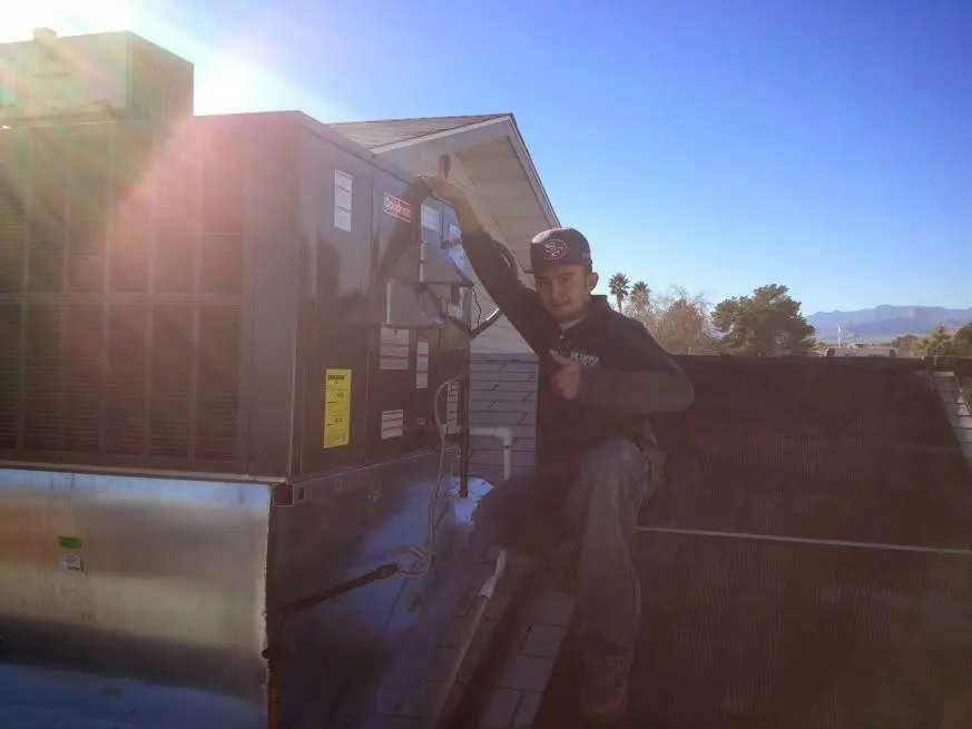HVAC technician performing Boiler Repair on a rooftop unit in Parsons